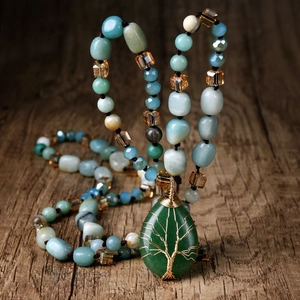 Macro detail of handmade bohemian knotted necklace with green amazonite beads and tree of life