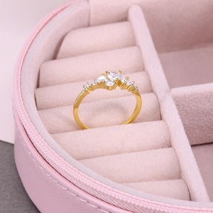 Macro shot of gold luxury ring with sparkling clear stones in a pink jewelry gift box