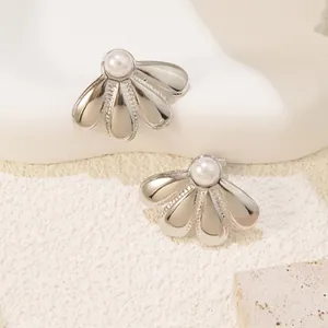 Elegant silver titanium flower stud earrings with central pearl on a stone display