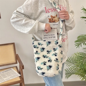 Close-up of white plush bucket bag featuring blue floral patterns and soft texture
