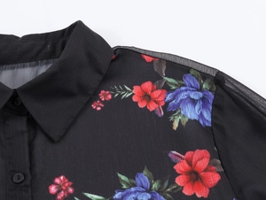 Dettaglio della camicia nera in chiffon trasparente con fiori e inserti in rete