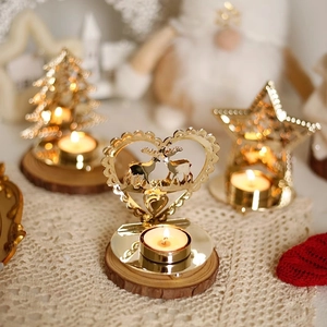 Golden iron Christmas candle holders with reindeer and star shapes on wooden bases
