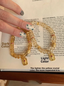Bracelet en perles de citrine jaune avec pendentif éléphant doré sur une page de livre