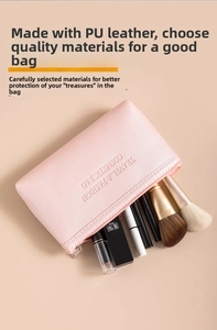 Pink PU leather makeup bag with cosmetic tools on a warm beige background