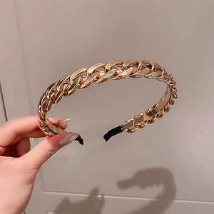 Close-up of a glossy gold resin chain headband with a metallic textured finish