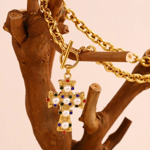 Detail of 18K gold-plated cross necklace with pearls and colorful gemstones on chunky chain