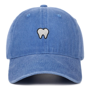 Vintage washed blue cotton baseball cap with white tooth embroidery on a white background