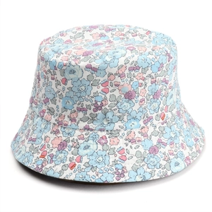 Detail of floral bucket hat featuring light blue and pink flower patterns on white cotton