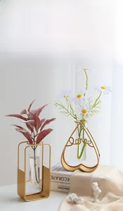 Close-up of gold metal frame glass vases with heart and rectangle shapes and love text