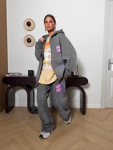 Détail d'un ensemble sweat à capuche gris foncé avec lettrage Saint Louis rose et t-shirt racing