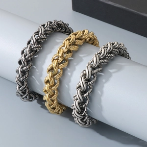 Detailed close-up of woven stainless steel chain bracelets in dark grey, gold and silver