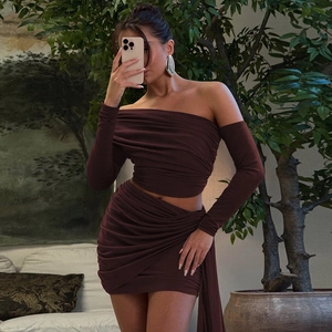 Detail of burgundy off-shoulder long sleeve top and ruched mini skirt set in elastic fabric