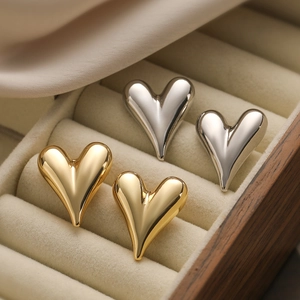 Pendientes de corazón minimalistas en oro y plata en un estuche de terciopelo