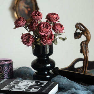Deep red artificial roses in black ceramic vase for vintage style home decor