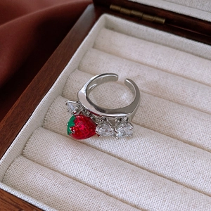 Detail of silver strawberry ring with heart-shaped crystals and red pendant in a wooden box