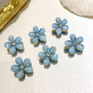 Macro detail of blue crystal flower hair clips with white rhinestone centers