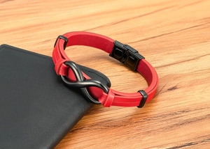 Detail of red braided leather bracelet with black infinity charm and stainless steel clasp