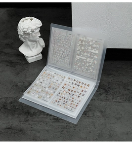 Detailed view of the transparent nail art sticker album with assorted cartoon patterns