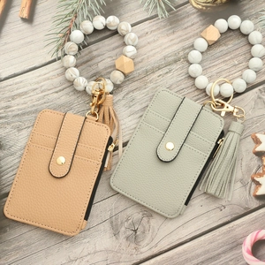 Silicone bead wristlet keychain with brown PU leather wallet and tassel on wooden background