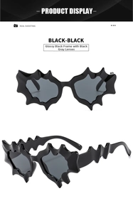 Detail of bat-shaped Y2K sunglasses in shiny black frame with black-grey lenses