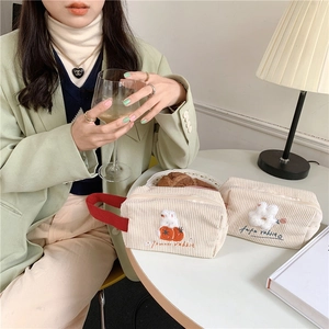 Nahaufnahme der floralen Hasenstickerei und Cord-Textur auf dieser Kosmetiktasche