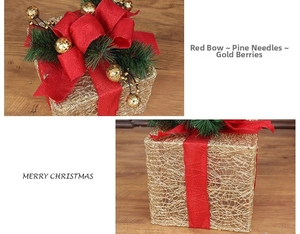 Detail of Christmas gift box with gold mesh structure, red burlap bow, and pine needles