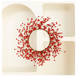 Dettaglio di una corona natalizia con bacche rosse artificiali su sfondo bianco moderno