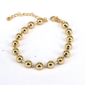Detail of minimalist golden bead bracelet with lobster clasp and adjustable link chain
