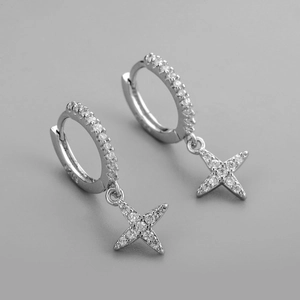 Macro de boucles d'oreilles étoiles en argent avec zircons brillants sur fond gris