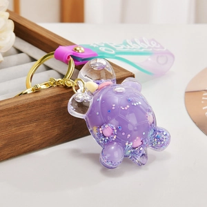 Detailed macro view of purple turtle liquid glitter keychain with bubble strap