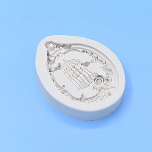Detailed relief of birdcage and rose patterns inside a teardrop silicone mold