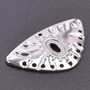 Macro shot of silver stainless steel eye charm pendant with embossed textures and details