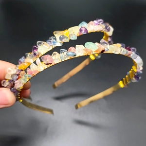 Close-up detail of handmade gold wire wrapping multi-color crystal stones on a metal headband