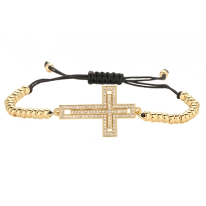 Adjustable black woven bracelet featuring a gold cross pendant with cubic zirconia inlay