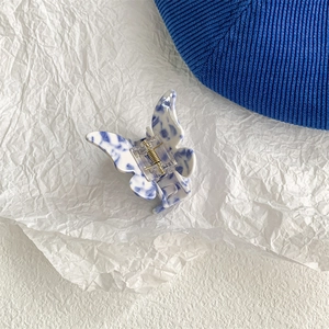 Detail shot of butterfly hair claw with blue and white porcelain marble pattern