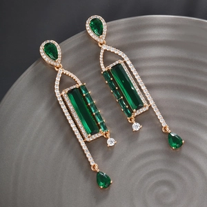 Detail of emerald green waterdrop earrings with gold-tone setting and pavé crystals
