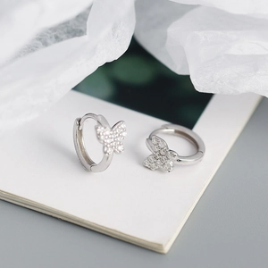 Detailed macro view of S925 sterling silver butterfly hoop earrings with sparkling crystals