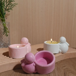 Minimalist animal resin candle holders in pink and white on a wooden tray with tea lights