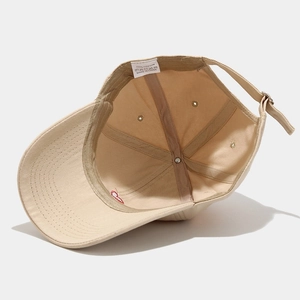 Detail view of khaki cotton baseball cap interior stitching and 100% cotton wash label