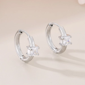 Detail of silver hoop earrings with a square clear stone in a secure 4-prong setting
