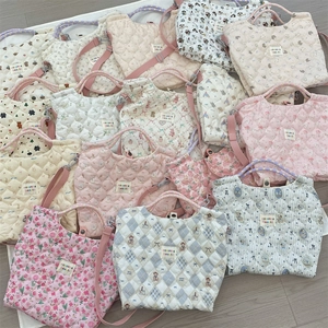 Détail de sacs en coton matelassé avec motifs floraux et dessins animés et sangles