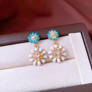 Boucles d'oreilles pendantes marguerite double dorées avec pétales bleus et blancs et cristaux