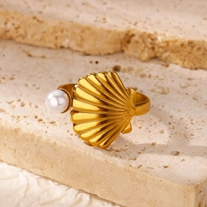 Detail of 18K gold-plated seashell ring featuring a white pearl on a textured stone