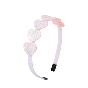 Detailed side view of a pink sequined heart headband with protective black end caps