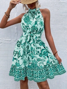 Detail of mint green floral halter dress featuring a waist-tie and elegant pleated skirt