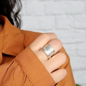 Anello punk vintage a fascia larga inciso con tarassaco su dito di una modella