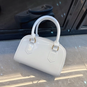 Detail of white jelly Boston bag with glossy finish and elegant gold hardware accents
