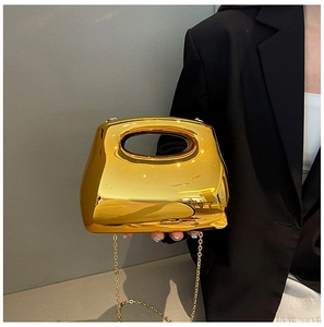 Close-up of a gold mirror finish acrylic clutch with integrated handle and chain strap