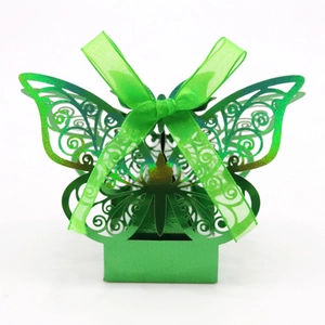 Detail of laser-cut green butterfly gift box with intricate patterns and silk ribbon bow