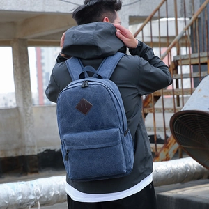 Classic dark blue canvas backpack for men and women featuring a diamond leather patch